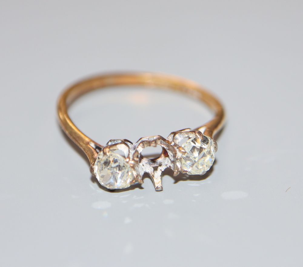 An 18ct and plat, two (ex three) stone diamond ring, size O/P, gross 2.4 grams.